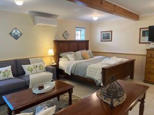 a bedroom with a bed and a couch at Banksia Cottage in Perth Hills in Perth