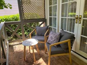 a porch with two chairs and a table and a stool at Banksia Cottage in Perth Hills in Perth