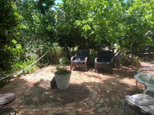 two chairs and a table on a brick patio at Banksia Cottage in Perth Hills in Perth +20 photos