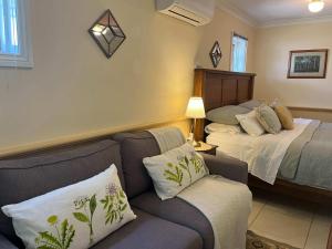 una sala de estar con un sofá y una cama en Banksia Cottage in Perth Hills, en Perth