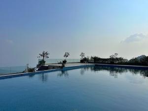 a large blue swimming pool with trees in the background at Valley Bungalow - Venuestay in Tam Ðảo +9 photos