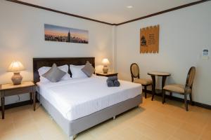 a bedroom with a bed and a table and chairs at Tri's Miracle Apartment Kata in Kata Beach +27 photos