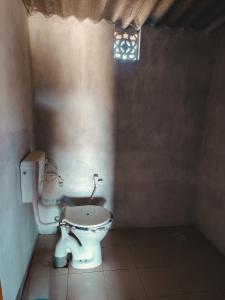 een badkamer met een toilet in een kamer met een raam bij Rann Dharti Homestay in Bherandiāla