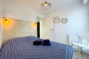 a bedroom with a bed with two towels on it at Pieds Dans L'Eau T2 Archi Cosy - Vue mer 180 in Ploemeur +19 photos