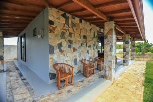 a stone wall with chairs on a patio at Mango Garden Dambulla in Dambulla