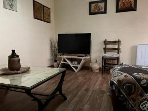 ein Wohnzimmer mit Fernseher und Couchtisch in der Unterkunft Apartamento Selva Blanca 9 in Villanúa