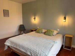 Un dormitorio con una cama con dos almohadas verdes. en l'Echappee belle Seaside break for 8 people, en Plougasnou