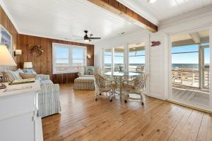 Una cocina y una sala de estar con mesa y sillas. en Laughin Place V home by Peace Vacations, en Pawleys Island