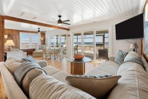 Una sala de estar con un sofá y un televisor de pantalla plana. en Laughin Place V home by Peace Vacations, en Pawleys Island