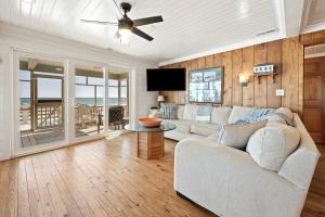Una sala de estar con un sofá y un ventilador de techo. en Laughin Place home by Peace Vacations, en Pawleys Island