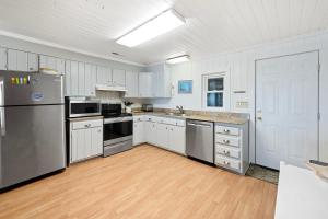 cocina grande con armarios blancos y electrodomésticos de acero inoxidable en Laughin Place home by Peace Vacations, en Pawleys Island 51 fotos más