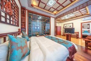 a bedroom with a large bed and a television at Dali Classical Rosewood Boutique Inn in Dali Ancient Town