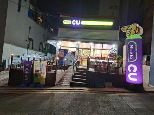 a gas station on the side of a street at night at 20프로할인 대전역 단독주택 우송대 복층형하우스 숮불바베큐하우스 in Daejeon