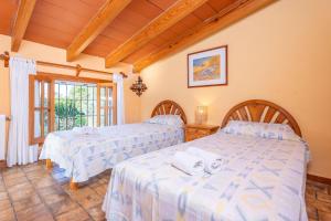 two beds in a room with a window at Finca Tito y Yaya in Alcudia +38 photos