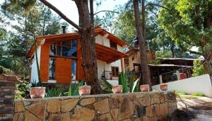 a house with a stone fence in front of it at Cabaña Casa Alpes Mazamitla in Mazamitla