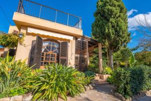 a house with a balcony and trees and plants at Finca Tito y Yaya in Alcudia