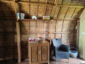 a room with a table and a chair in a straw hut at Playa Encantada Beach Resort in El Nido