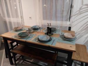 een houten tafel met borden en glazen erop bij Astérix- CDG Aéroport de Paris - Parc expos Villepinte in Louvres