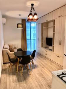 een keuken en woonkamer met een tafel en stoelen bij Horizon Batumi Aparthotel in Batoemi