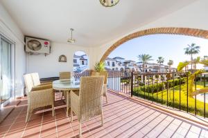 Un comedor con mesa y sillas en un balcón. en Al Andalus Residencial Vera Playa 2, en Vera