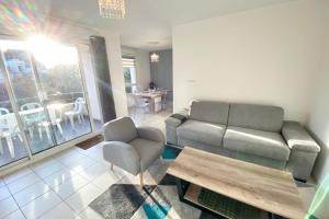 una sala de estar con un sofá y una mesa en Joli T3 super cosy À 2 pas des plages, en Ploemeur