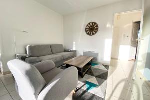 una sala de estar con un sofá y una mesa en Joli T3 super cosy À 2 pas des plages, en Ploemeur