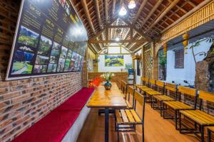 a restaurant with wooden tables and chairs and a brick wall at Tam Coc Moonlight Sweet Home in Ninh Binh