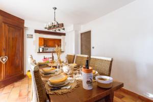 a dining room with a wooden table with chairs at Le Mélomane - Maison climatisée avec jardin clos in Montfrin