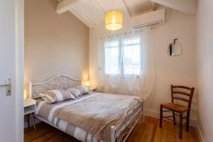 a bedroom with a bed and a desk and a window at Le Mélomane - Maison climatisée avec jardin clos in Montfrin +15 photos