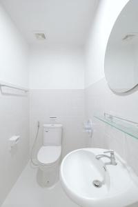 Un baño blanco con inodoro y lavabo. en Wit Haus Nimman, en Chiang Mai 46 fotos más