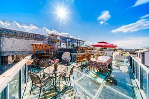 a balcony with tables and chairs on top of a building at Dali Classical Rosewood Boutique Inn in Dali Ancient Town