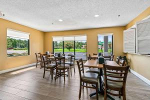 una sala da pranzo con tavoli, sedie e finestre di Quality Inn Quincy - Tallahassee West a Quincy