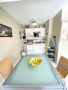 a kitchen with a table and two chairs at T2 Top Cosy Balcon 150m des plages in Carnac +16 photos