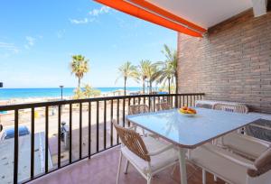 a balcony with a table and chairs and the beach at La Paz by 10toSea in Fuengirola