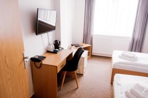 una camera d'albergo con una scrivania e una televisione di Hotel Arena Liberec a Liberec
