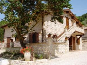 a white brick house with a tree in front of it at Complesso Agrituristico La Ciriola in Piediluco