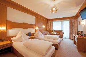 una habitación de hotel con dos camas y una mesa en Hotel Antony, en Ischgl