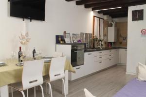 a kitchen with a table with white chairs and a counter at Casa Elia in Venice +23 photos