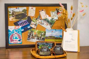 a table with two vases and a basket with a picture at XÔI Setai Suites Linh Lang in Hanoi