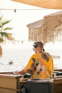 a man sitting at a desk in front of the water at Maya Beach Resort in Massa Lubrense