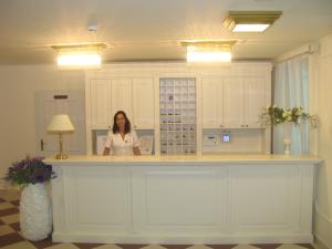 a woman standing at a counter in a room at Hotel Villa Elisabeth - Veli Lošinj Health Resort in Veli Lošinj