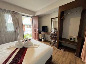 two swans are sitting on a bed in a hotel room at Panna Heritage Boutique Hotel - SHA Plus in Chiang Mai