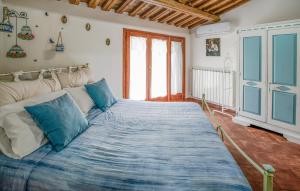 ガンバッシ・テルメにあるLovely Home In Gambassi Terme With Wifiの青い枕が付いた大きなベッドのある寝室