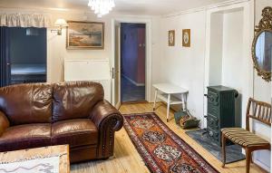 a living room with a leather couch and a table at 2 Bedroom Lovely Home In Færvik in Færvik