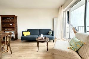 a living room with a blue couch and a table at Lovely ! T3 Duplex Hyper Cocooning in Quiberon