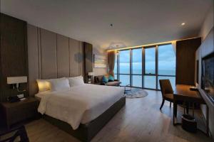芽庄Panorama Beach Pearl Nha Trang Residences的一间配有床、书桌和电脑的酒店房间