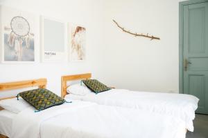two beds in a room with white walls at חאן טשרניחובסקי in ‘Ofer