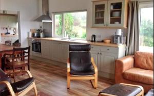 a kitchen and living room with a couch and a table at Finest Retreats - Beach Cove in Hodgeston