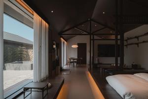 a bedroom with a bed and a living room with a table at Generous Jeju in Jeju