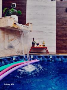 - une piscine avec une fontaine dans une maison dans l'établissement Piscina e Churrasqueira - 8 minuto a pé da Praia, à Mongaguá